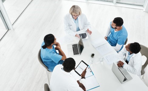Five doctors sitting at a desk