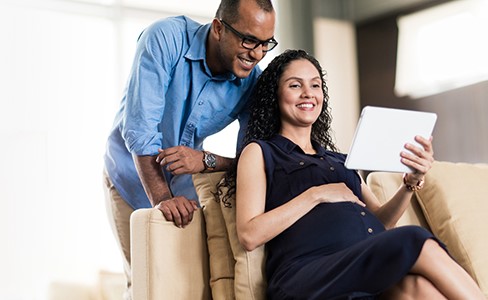 Husband and wive looking at tablet while smiling