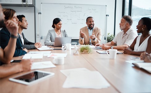 Diverse group of people sitting around a desk at the office